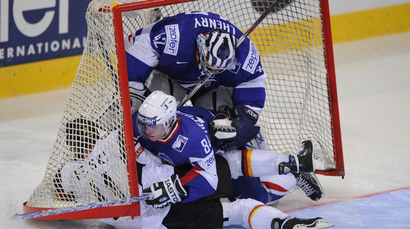 Vācijas hokejists Svens Felski neveiksmīgi cenšas iekarot Francijas vārtus. Foto: AFP