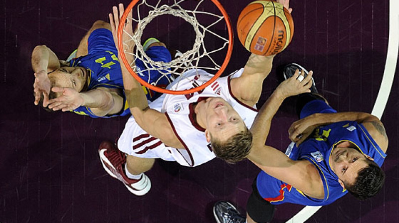 Kaspars Bērziņš cīnās pie Rumānijas izlases groza.
Foto: FIBAEurope (Romāns Kokšarovs)