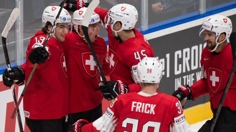 Šveices hokeja izlases spēlētāji svin pirmo vārtu guvumu. Foto: AFP/Scanpix