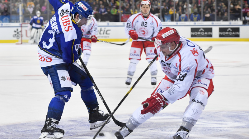 Guntis Galviņš (Nr. 58) cīņā par ripu. Foto: Gian Ehrenzeller/AP/Scanpix