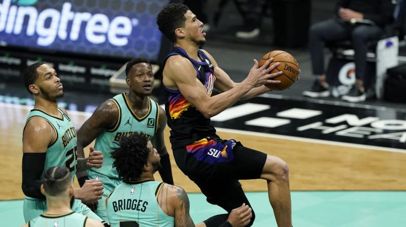 "Hornets" spēlētāji un Devins Bukers. Foto: AP/Scanpix