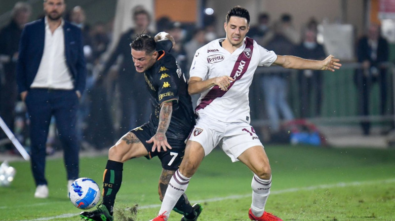 "Venezia" futbolists Paskāle Mezoki ar bumbu pret "Torino" vārtu autoru Josipu Brekalo. Foto: Ettore Griffoni/Reuters/Scanpix