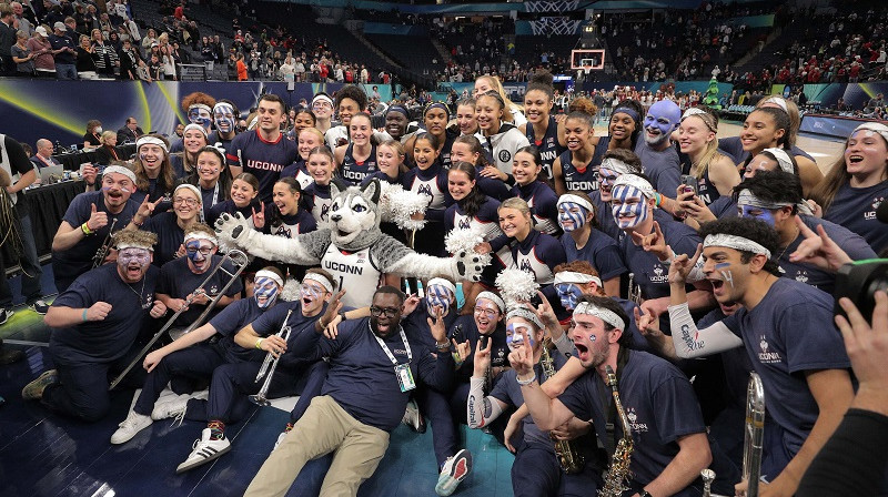 "UConn" spēlētājas, talismans un orķestris 2022. gada 1. aprīlī Mineapolē. Foto: USA Today/Scanpix