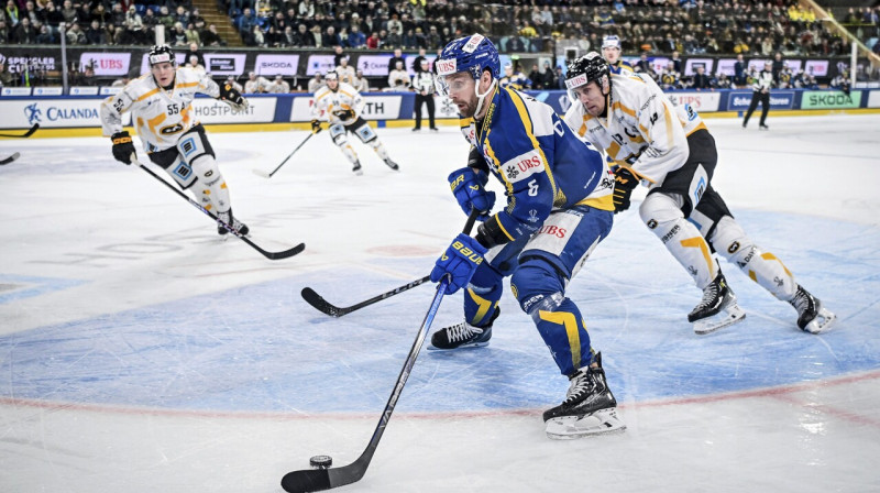 Davosas komandas aizsargs Klāss Dālbeks ar ripu cīņā pret Oulu "Kärpät". Foto: Melanie Duchene/AP/Scanpix