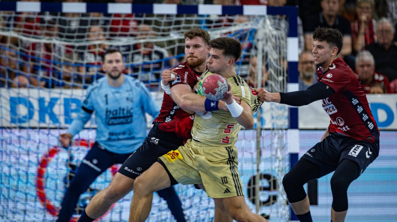 Renārs Uščins Flensburgas komandas spēlētāju tvērienā. Foto: Mario Koberg/Beautiful Sports/Scanpix